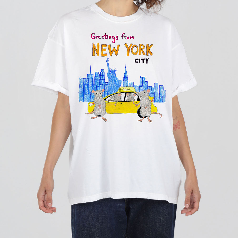 A person wearing a white t-shirt with a colorful print featuring cartoon mice, a yellow taxi, and a skyline with "greetings from new york city" text.