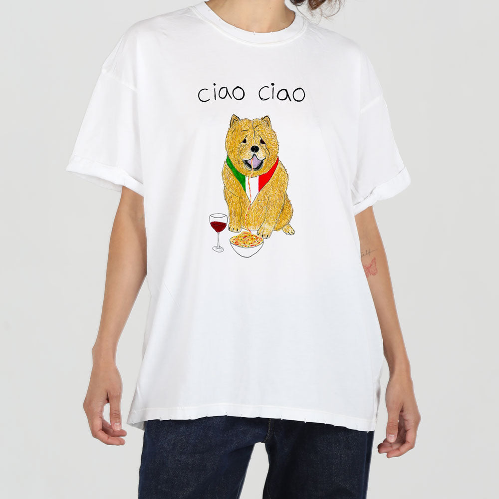 A person wearing a white t-shirt with a graphic print of a cartoon dog holding a glass of red wine and a plate of spaghetti, with "ciao ciao" written above.