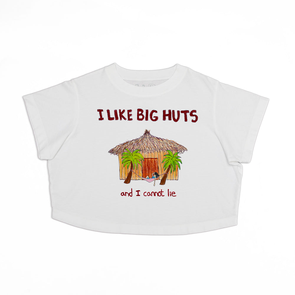 A white t-shirt with the text "i like big huts and i cannot lie" featuring an illustration of a large tropical hut surrounded by palm trees.