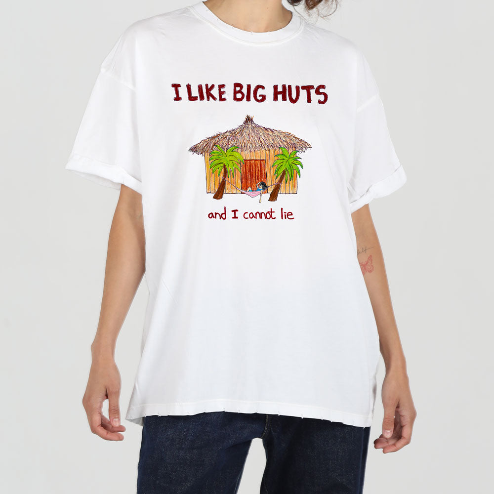 A person wearing a white t-shirt featuring the slogan "i like big huts and i cannot lie" with a graphic of a tropical hut and palm trees on the front.