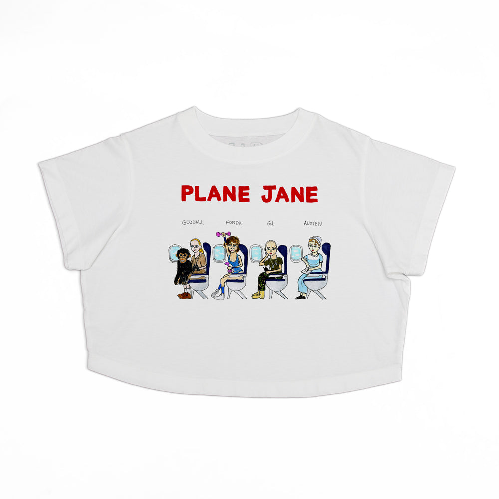 White cropped t-shirt with the text "plane jane" in red above a graphic of six diverse animated characters seated in airplane seats.