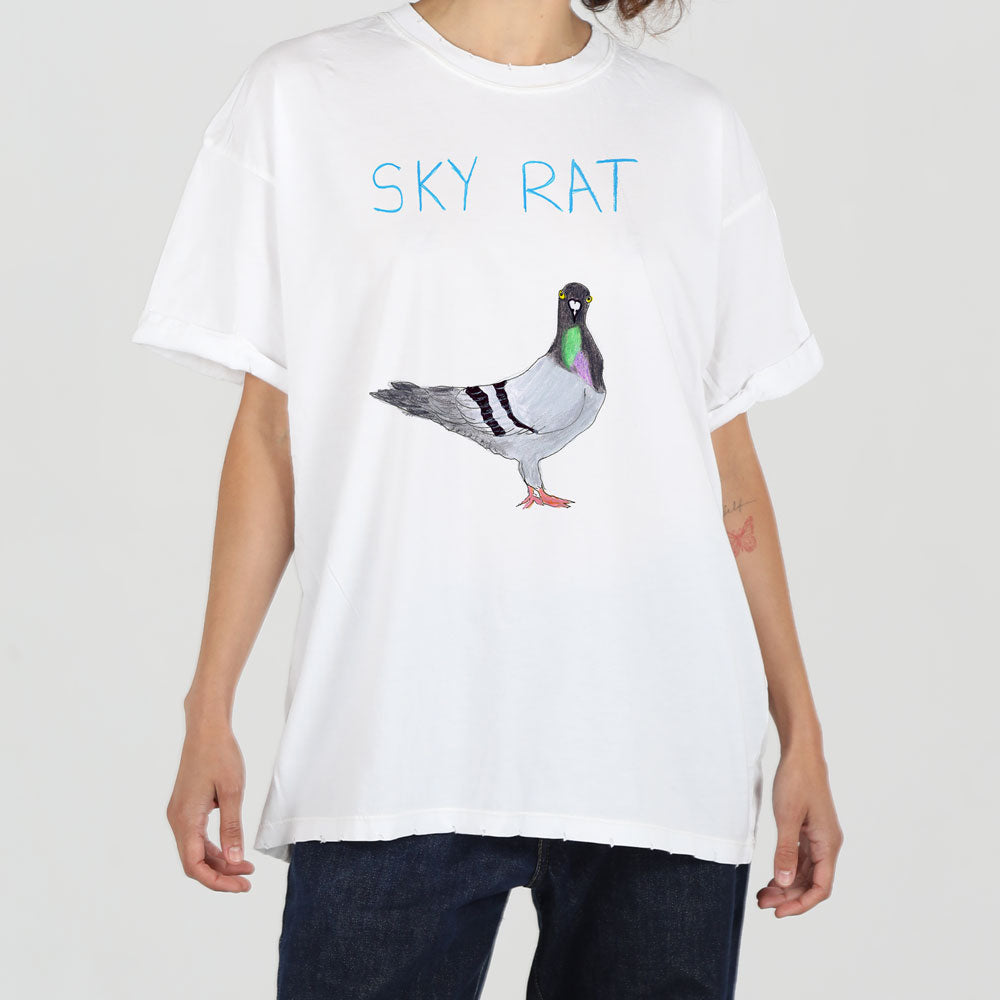 A person wearing a white t-shirt featuring a realistic pigeon illustration with the text "sky rat" above it. the shirt is loose-fitting and styled in a casual fashion.
