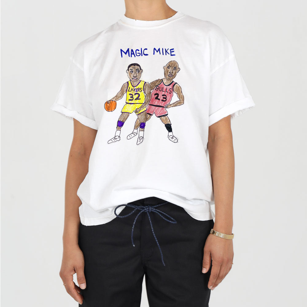 A person wearing a white t-shirt featuring colorful illustrations of two famous basketball players, one from the lakers and one from the bulls, with the phrase "magic mike" above.