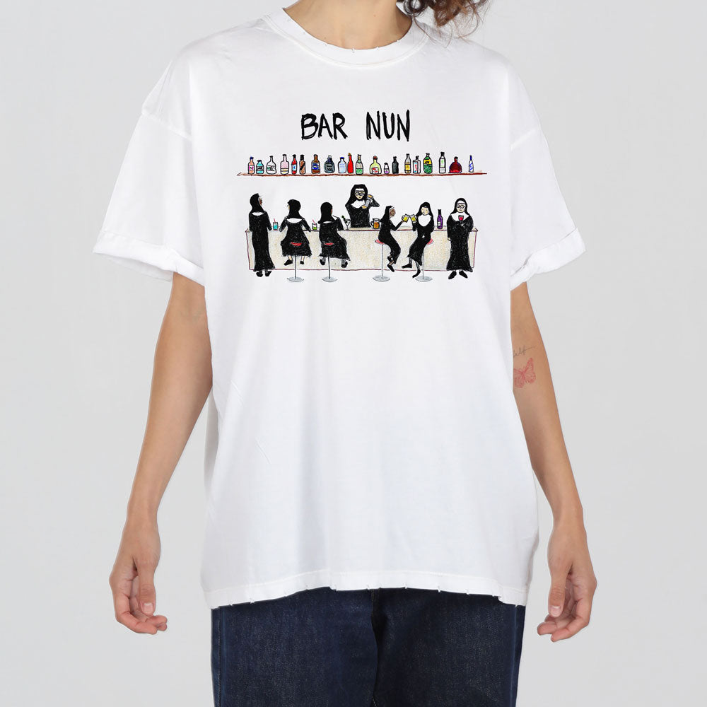 A person wearing a white t-shirt featuring a graphic of various nuns having drinks at a bar, with the text "bar nun" above the illustration.