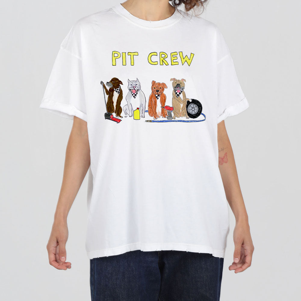 A person wearing a white t-shirt with "pit crew" printed on it, featuring cartoon drawings of various dogs dressed in racing crew outfits.