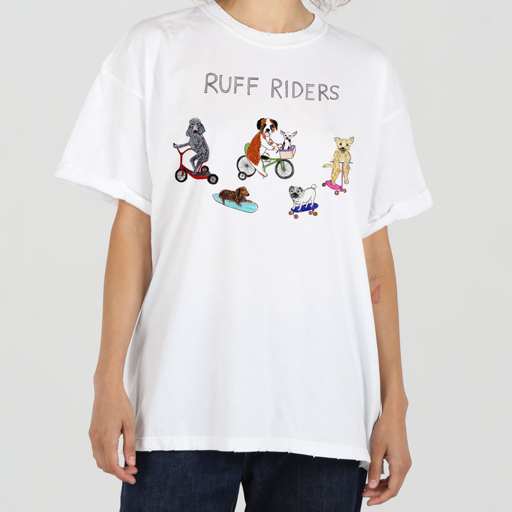 A person wearing a white t-shirt with "ruff riders" printed above a graphic of four dogs engaging in various activities: one skateboarding, one on a scooter, one on a bike, and one rollerblading.