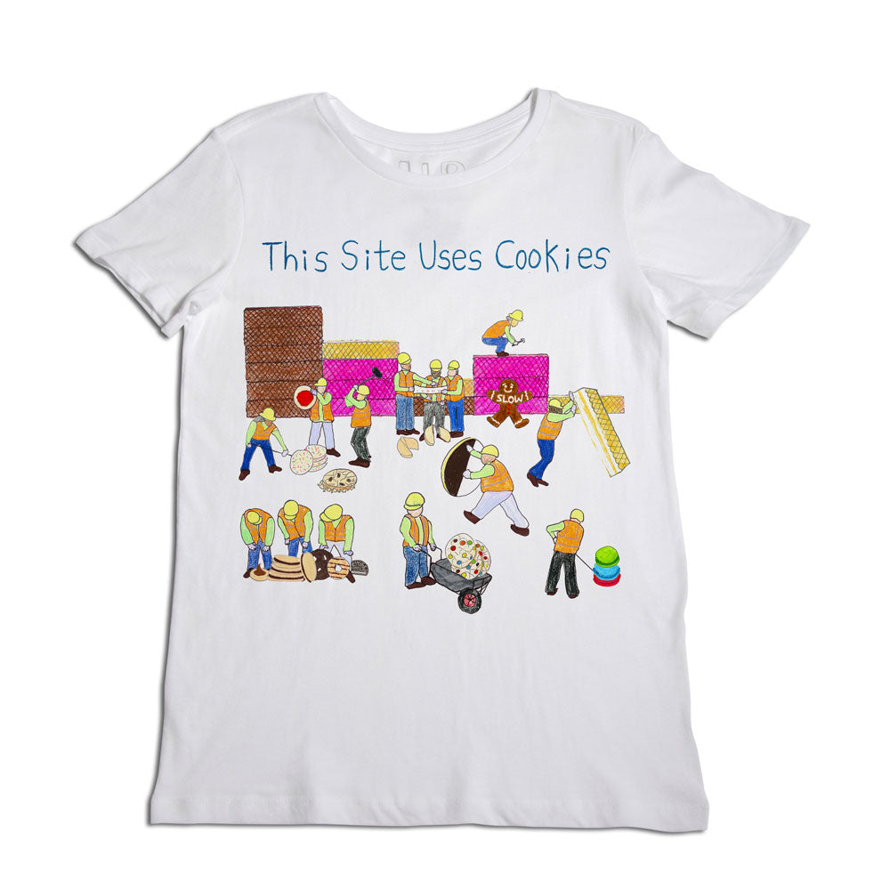 A white t-shirt with a colorful graphic print featuring mini cartoon characters engaged in baking, with the text "this site uses cookies" presented in a playful font at the top.