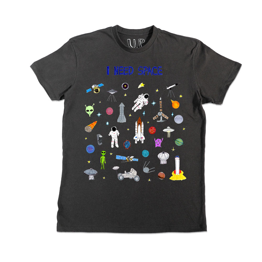 A black t-shirt features colorful space-themed graphics, including rockets, astronauts, planets, UFOs, and aliens. The text "I NEED SPACE" is printed at the top.