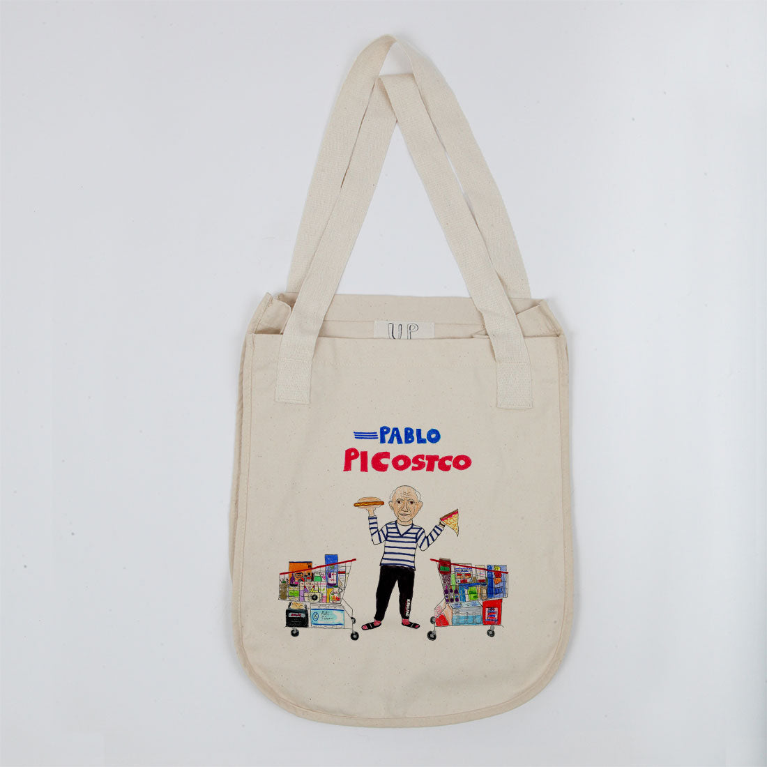 A canvas tote bag featuring a humorous illustration of pablo picasso as "pablo picostco," depicted with a shopping cart filled with art supplies, against a plain background.