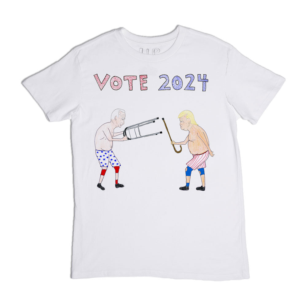 White t-shirt with a graphic design showing two cartoonish figures with exaggerated features, one with blue and one with red boxing gloves, engaging in a tug-of-war over a large pencil labeled "vote 2024.