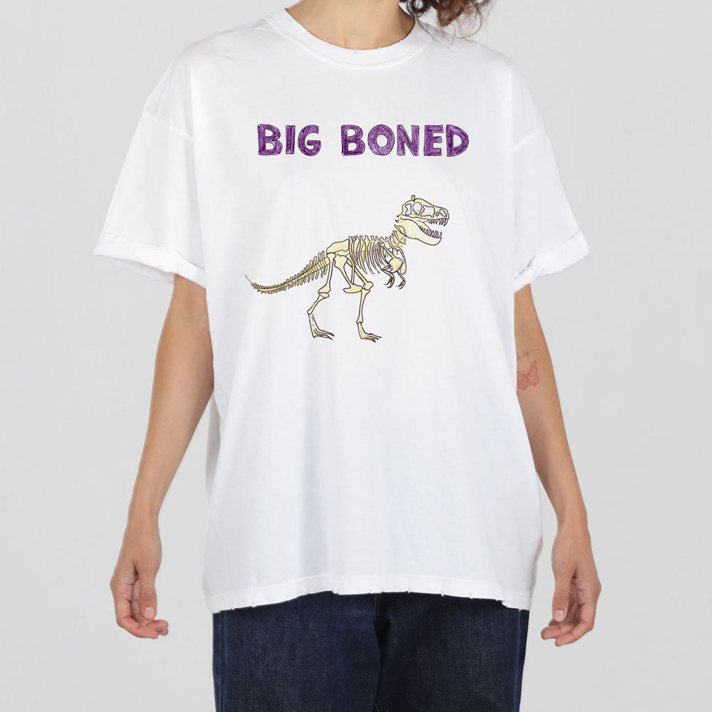 A person wearing a white t-shirt with the phrase "big boned" in purple text above a graphic of a dinosaur skeleton.