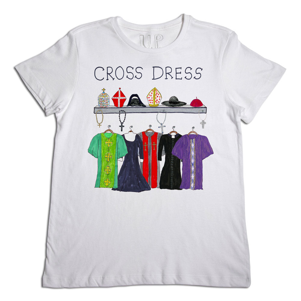A white t-shirt with a design featuring five different styles of clergy robes hanging on a rack, each topped with a coordinating bishop's mitre. the words "cross dress" appear at the top.