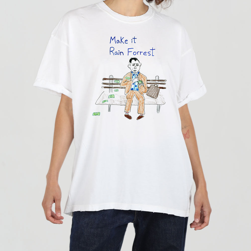 A white t-shirt with an illustration of forrest gump sitting on a bench, surrounded by money and a phrase "make it rain forrest," worn by a person against a plain background.