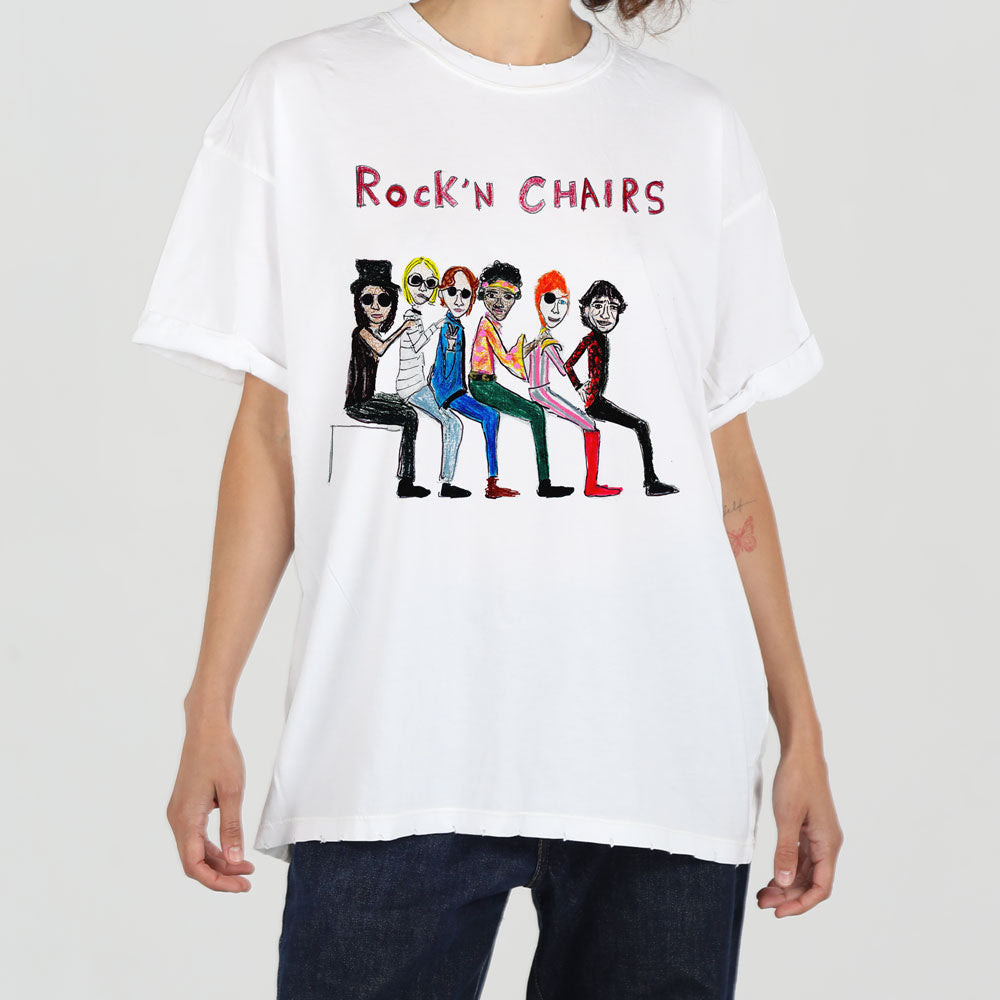 A person wearing a white t-shirt with a colorful illustration of four cartoonish characters sitting on chairs, styled as a band, labeled "rock'n chairs.