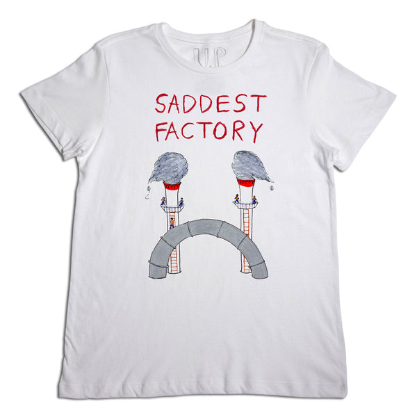 White t-shirt featuring the phrase "saddest factory" in red letters, with a graphic of two gloomy clouds raining on a gray, arched structure, all resembling a face with tears.