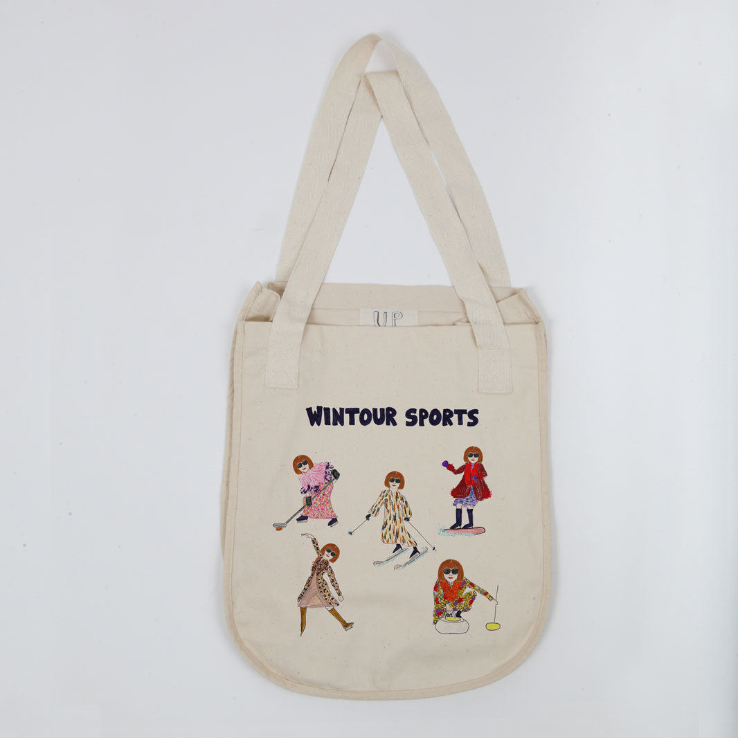 A cream-colored canvas tote bag with "wintour sports" printed at the top, featuring colorful embroidered illustrations of five women engaged in different sports activities.